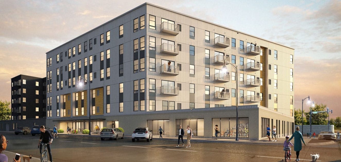 a building with many windows and cars on the street.