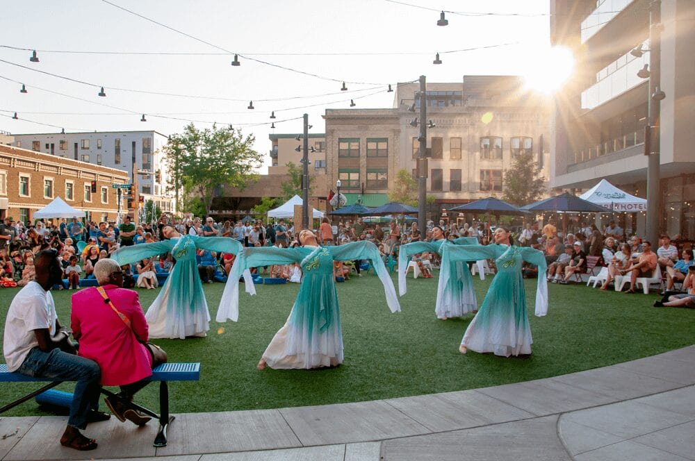 A group of people in dresses dancing in a park