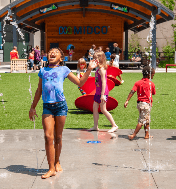 a girl playing with water in a park.