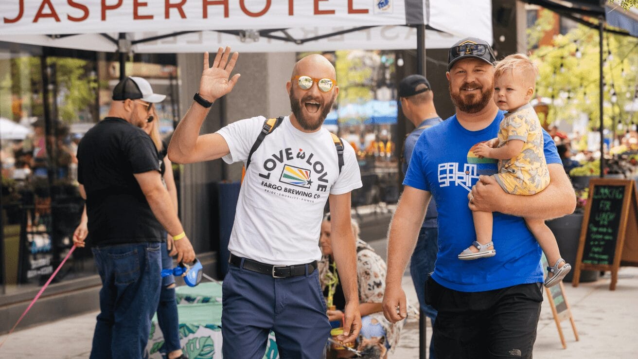 a man waving and holding a baby.