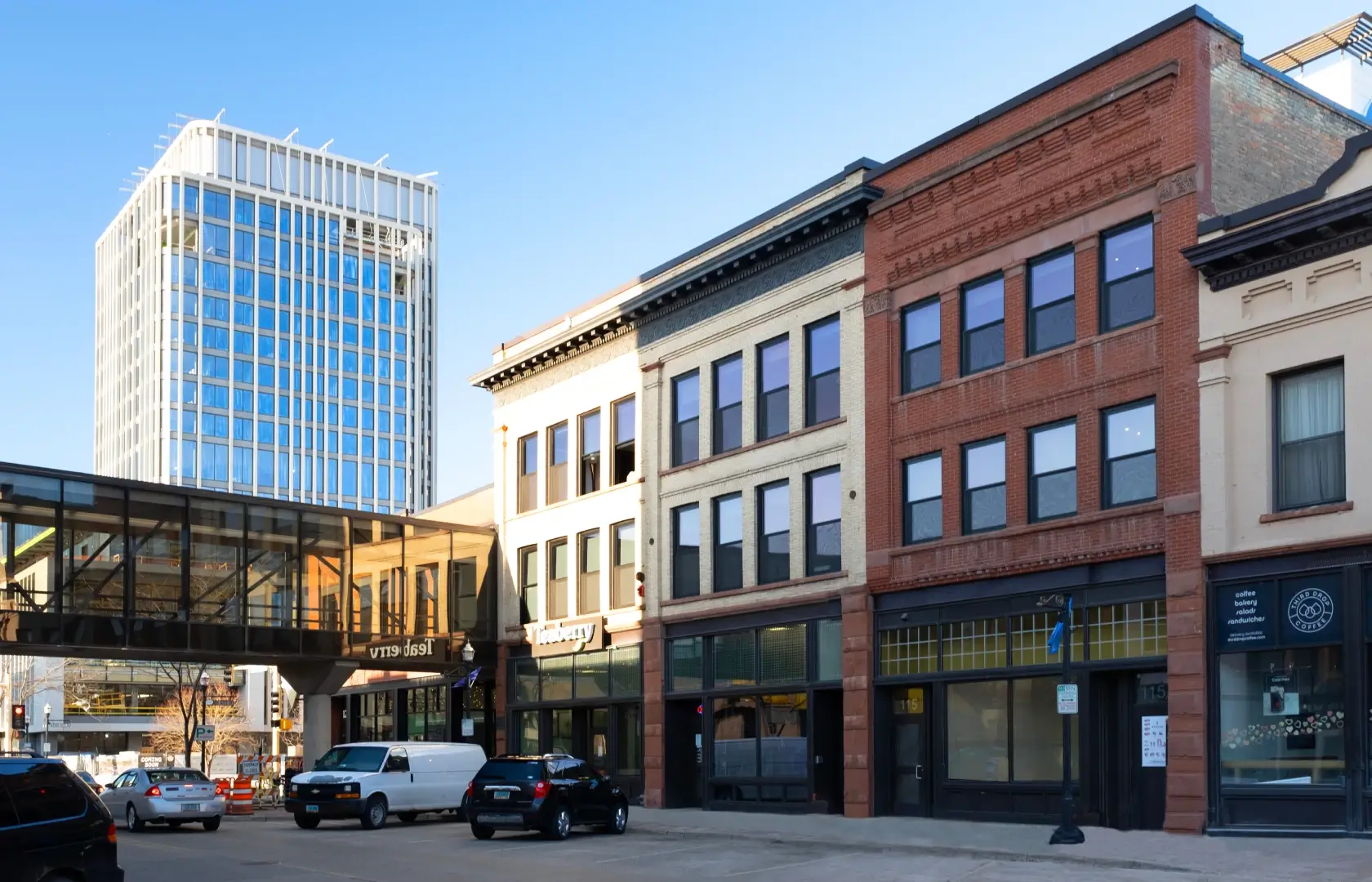 Bostad building with a row of buildings and cars parked in front.