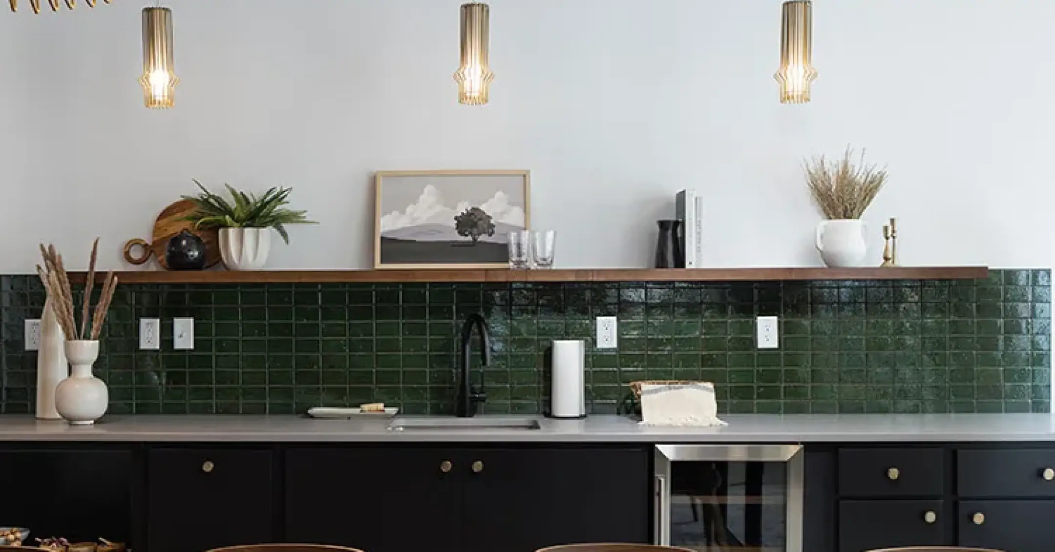 a kitchen with a green tile wall and a picture from the ceiling.
