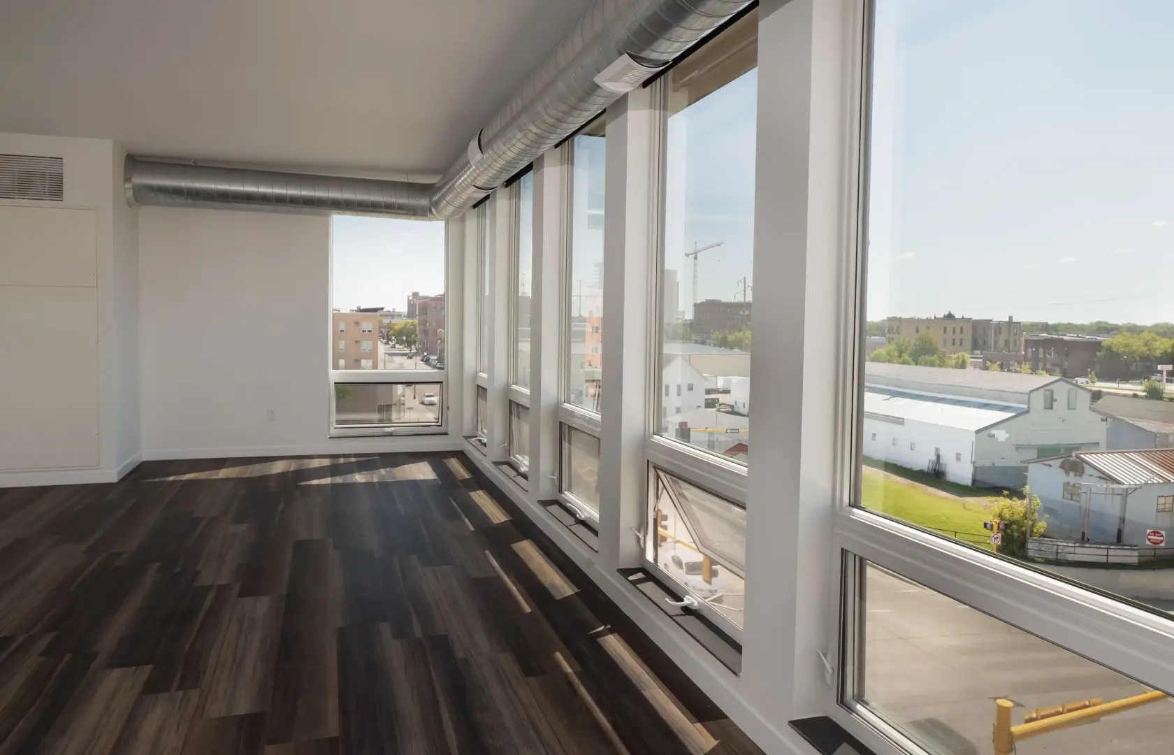 a room with large windows and wood floor