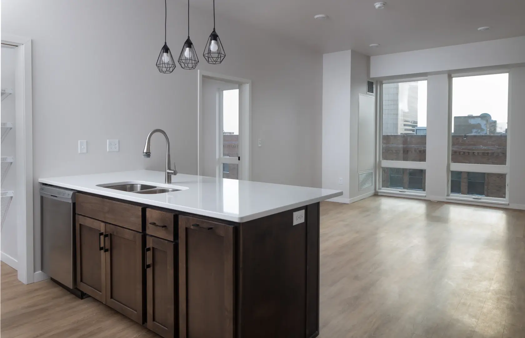 Mercantile apartment with a kitchen featuring a sink and wood flooring.
